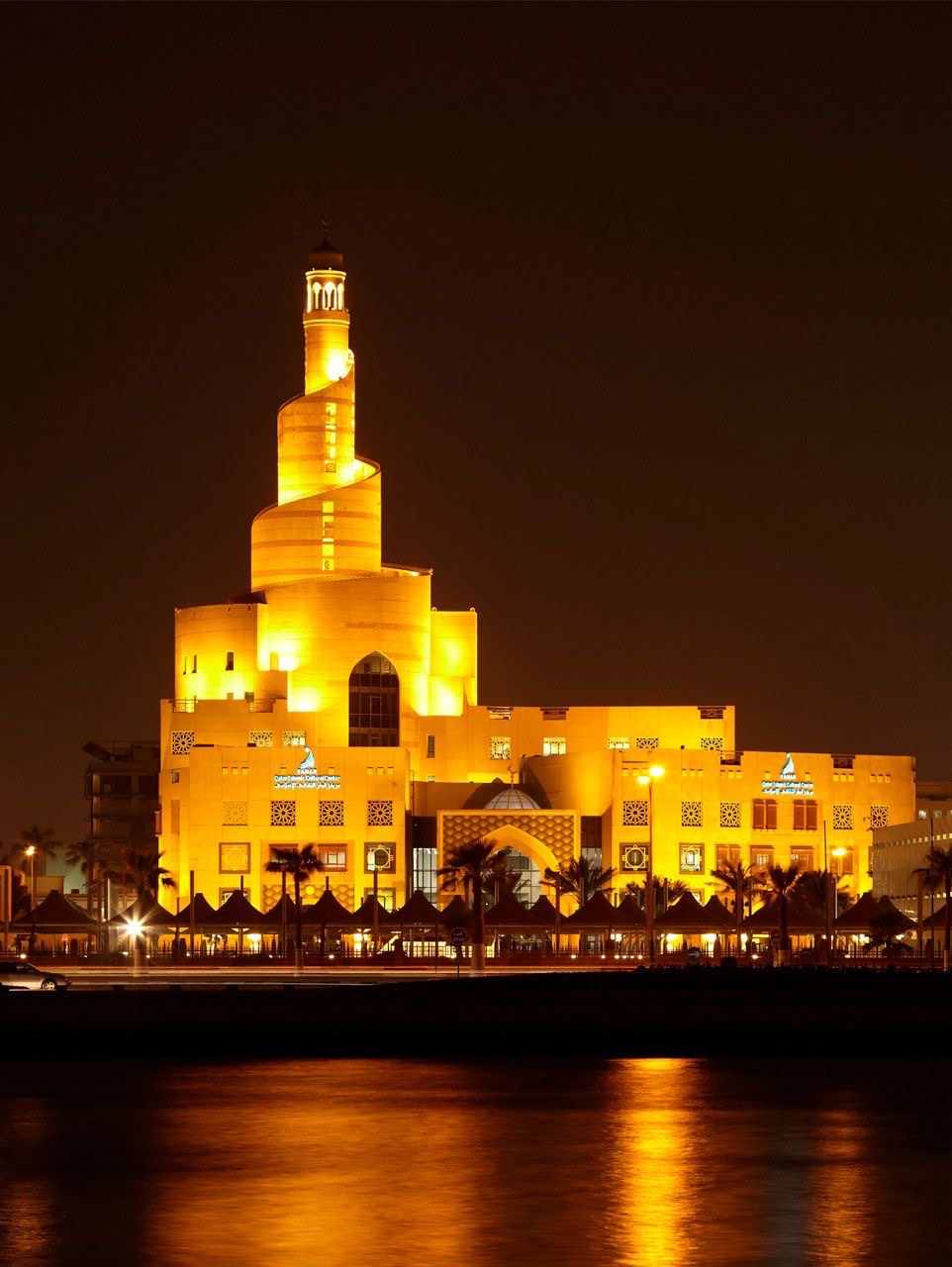 The spiral minaret of the Fanar Islamic Cultural Centre lit at night