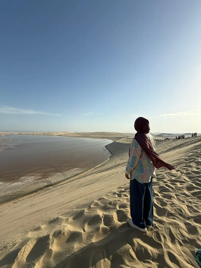A guest standing on a dune high above the inland sea