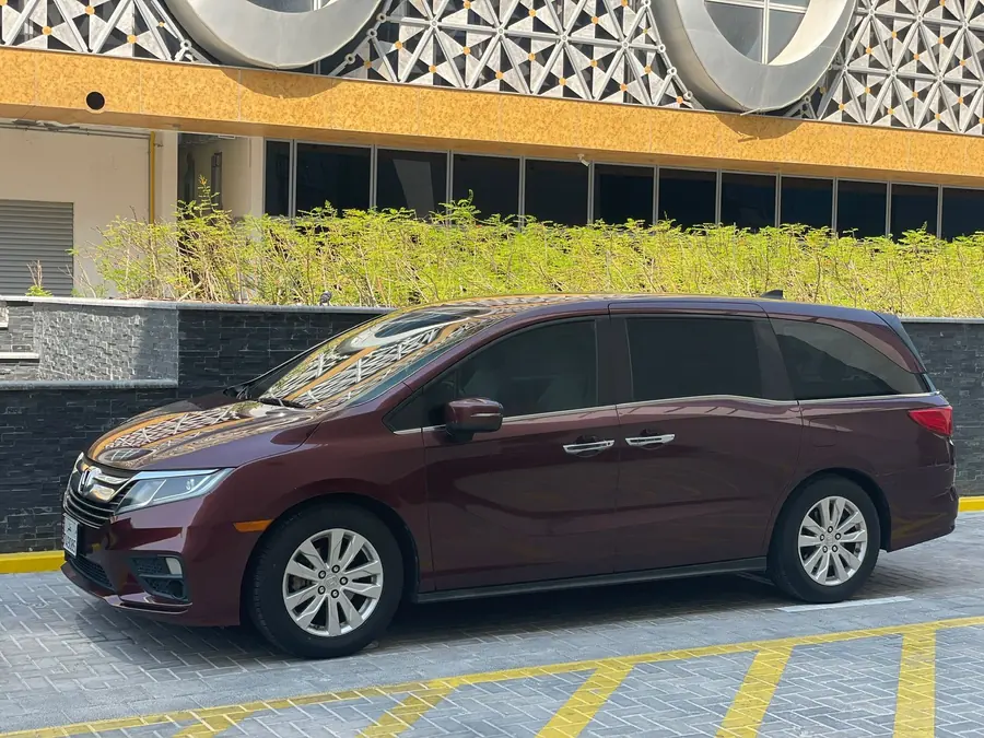 A maroon Honda Odyssey parked ready for a private transfer