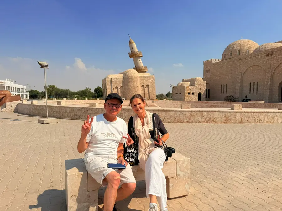 Guests seated below the domes and fort walls of Souq Waqif