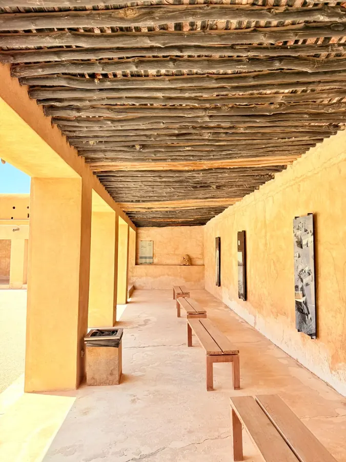 A shaded corridor with a timber-beam ceiling in old Doha