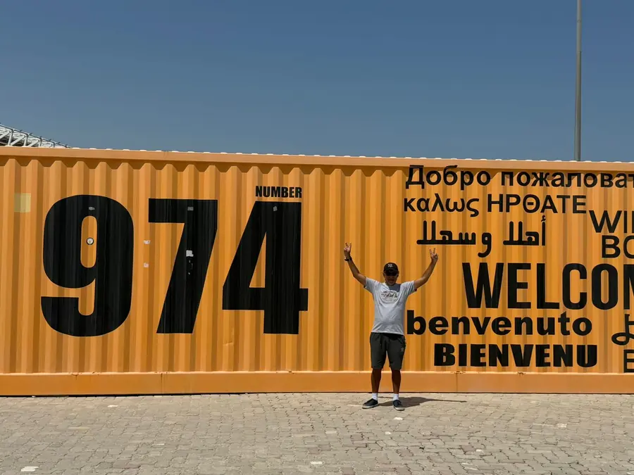 A guest with arms raised at the multilingual welcome container